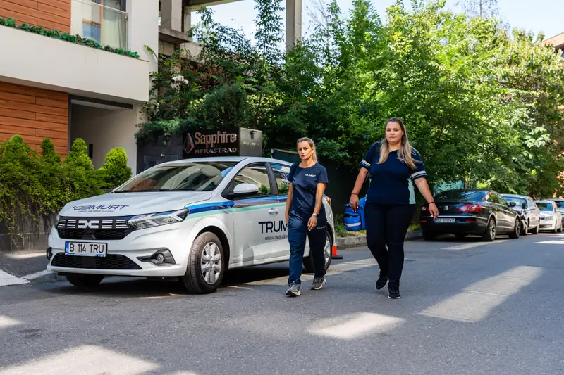 Trei membri ai echipei TRUMED, lângă mașina companiei
