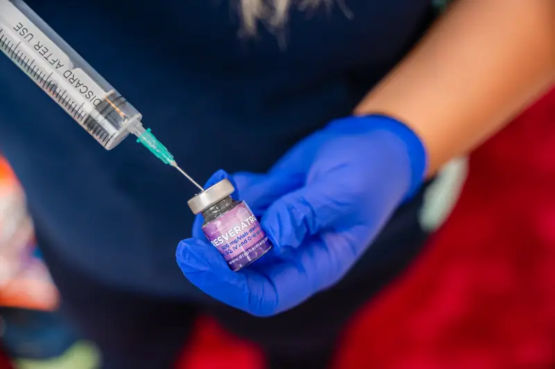 Asistent medical trage tratamentul în seringă dintr-un flacon, înainte de injecție
